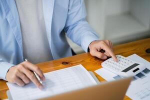 a man is using a calculator to do some calculations photo