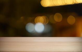 empty wooden table top on blurred background with bokeh effect photo