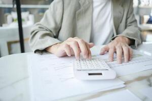 a businessman is using a calculator to do some calculations photo