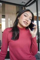 Asian Business woman using smart phone spending time checking news cell telephone technology e-commerce photo