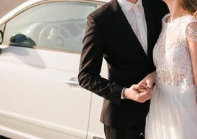 The bride and groom hold hands on their wedding day ir in love on a sunny day. Wedding concept. Copy space photo