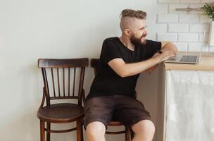 Smiling man working with laptop at home. Technology, home and lockdown concept. Copyspace and space for advertising photo
