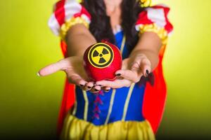 Woman holding hazardous radioactive apple. Nuclear and radiation measurement concept, close-up. photo