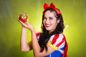 Funny girl wearing a fairy tale dress holding an apple with radiation symbol. Environmental problems concept, radioactive disaster as danger on nature. photo