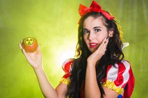 Portrait Surprised woman dressed as fairytale character holds Radioactive atomic nuclear ionizing radiation danger warning symbol on apple. Nuclear and radiation measurement concept. photo
