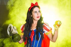 Female dressed as fairytale character holds Radioactive atomic nuclear ionizing radiation danger warning symbol on apple. Nuclear and radiation measurement photo