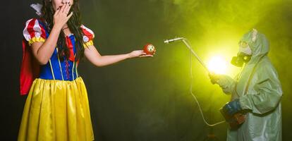 Banner Woman dressed as fairytale character holds Radioactive atomic nuclear ionizing radiation danger warning symbol on apple. Nuclear and radiation measurement concept. photo