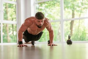 Beautiful view through, the windows. .Strong muscular man is working out in the gym photo