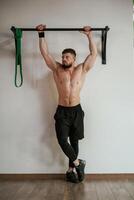 Strong muscular man is working out in the gym photo