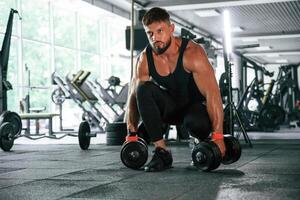 Heavy weights ,in ,hands. Strong muscular man is working out in the gym photo