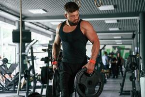 Heavy weights in ,,hands. Strong muscular man is working out in the gym photo