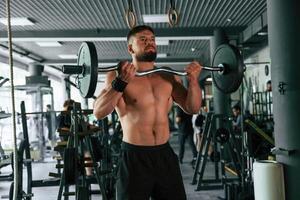 Muscular,, strong man is working out in the gym photo