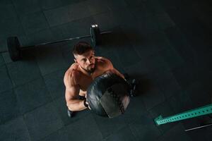 Top view, throwing the fitness ball. .Strong muscular man is working out in the gym photo