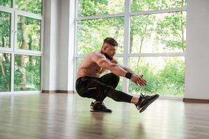Yoga stretching. Strong muscular, man is working out in the gym photo