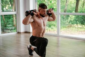 With heavy, dumbbells.,, Strong muscular man is working out in the gym photo