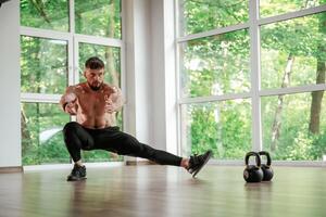 Focused ,at ,,the exercise. Strong muscular man is working out in the gym photo