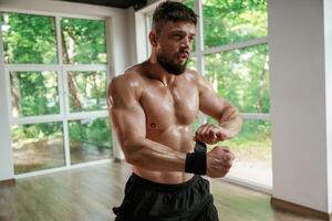 Wearing the protective bandage ,,on hands. Strong muscular man is working out in the gym photo