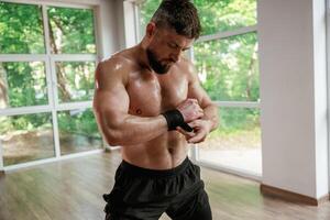 Wearing the protective bandage ,on hands. Strong muscular man is working out in the gym photo
