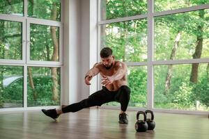 Focused at the exercise. .Strong muscular man is working out in the gym photo