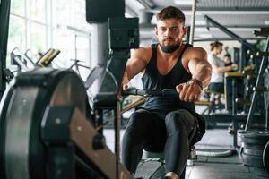 Exercise for, stamina. Strong muscular man is working out in the gym photo