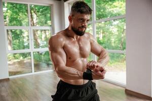 Wearing the, protective bandage on hands. Strong muscular man is working out in the gym photo