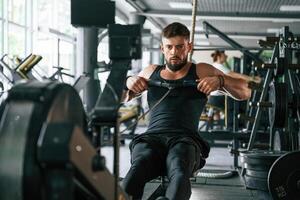 Exercise, for stamina. Strong muscular man is working out in the gym photo