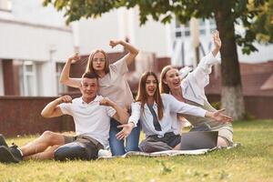 Posing and smiling. Group ,,of students ,are outside together photo