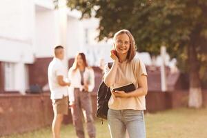 Girl ,is with digital tablet. Group of students are outside together photo