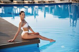 Positive, vibes., Beautiful woman in bikini is resting by the pool photo