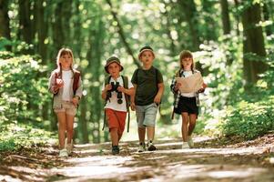 Conception of hiking.. Kids in forest at summer daytime together photo