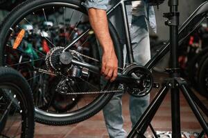 Close up view of man's hands that is repairing bicycle,, photo