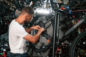 Focused ,at ,,job. Repair, man in bicycle shop, working in store photo
