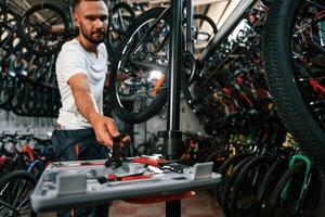 Bunch of tools. Repair man in bicycle shop, working in store photo