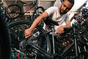 Adjusting the wheel.. Repair,, man in bicycle ,shop, working in store photo