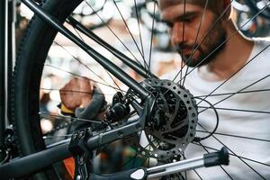Cleaning ,the, chain., Repair man in bicycle shop, working in store photo