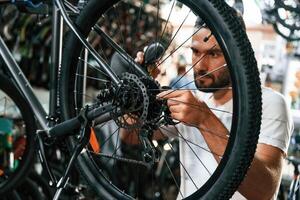 Focused at job., Repair man in bicycle shop, working in store photo