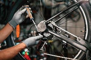 Fixing, the, derailleur.... Close ,,up view of man's hands that is repairing bicycle photo