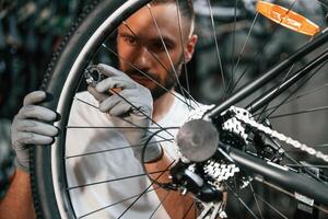 Spokes ,replacement. Repair, man ,,in bicycle shop, working in store photo