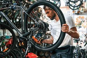 Focused at job. ,,Repair ,man ,in bicycle shop, working in store photo