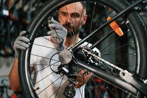Spokes replacement. Repair ,man,,, in bicycle shop, working in store photo