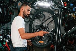 Focused ,at,, job. Repair man in bicycle shop, working in store photo