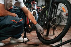 Inflates a, tire, with hand pump. Close up view of man's hands that is repairing bicycle photo
