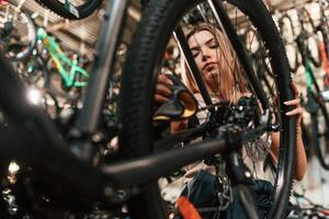 Repair woman in bicycle shop, working in, store photo