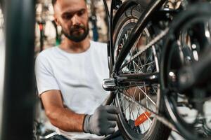 Final ,adjustments. Repair, man ,in bicycle shop, working in store photo