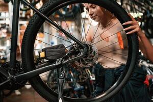 Making it, clean. ,,Repair woman in bicycle shop, working in store photo