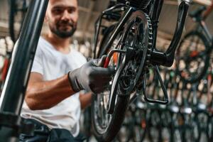Indoors, many bikes. Repair ,,man, in bicycle shop, working in store photo