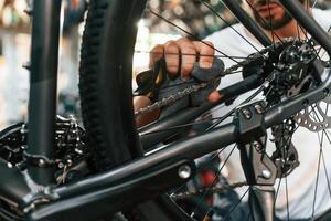 Rear ,wheel ,,adjustment. Repair man in bicycle shop, working in store photo