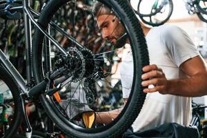 Cleaning the chain. Repair man ,in bicycle shop, working in store photo
