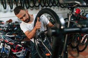 Final, adjustments.. Repair man in bicycle shop, working in store photo