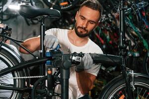 Professional ,occupation. Repair man in bicycle shop, working in store photo